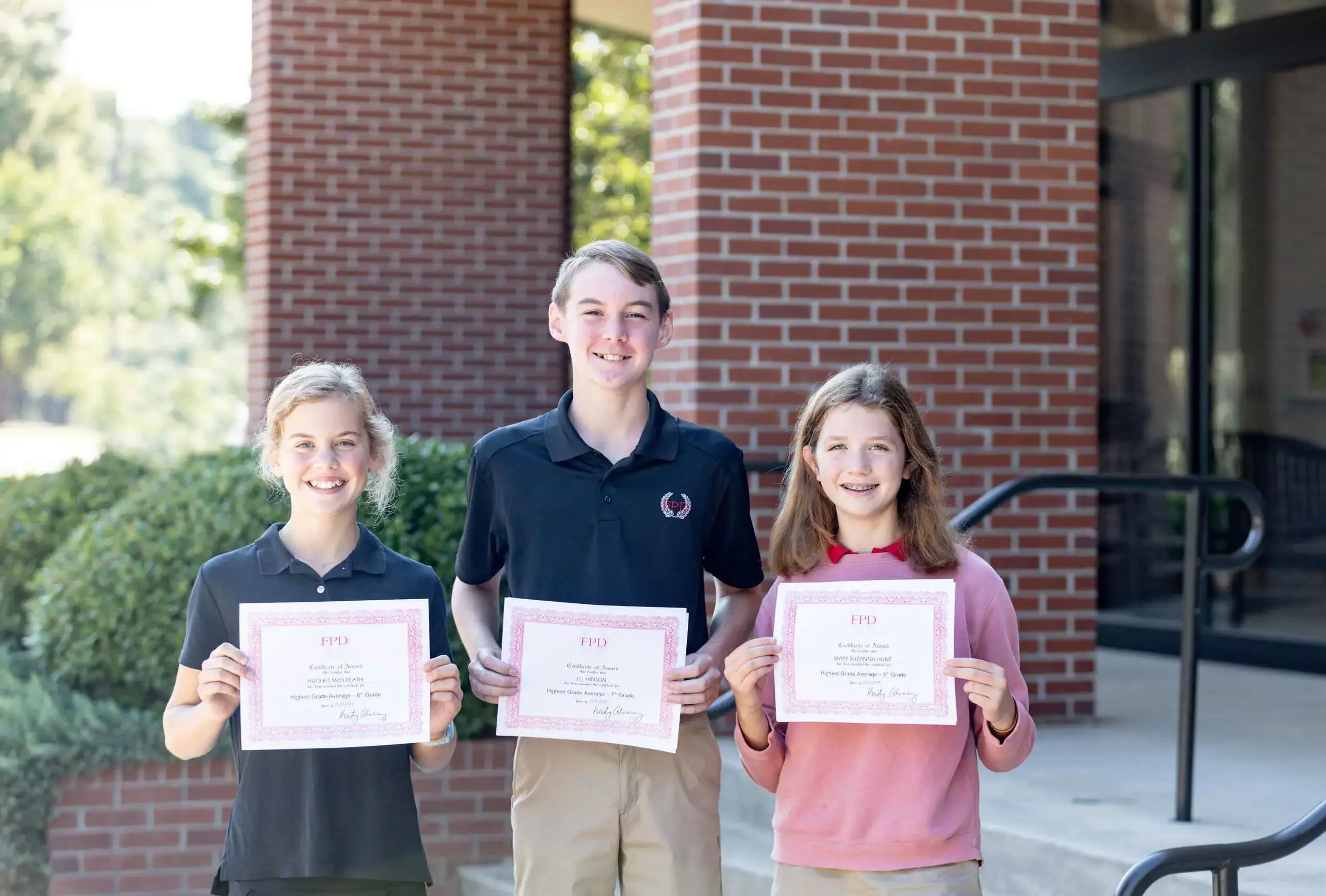 smiling students with awards certificates